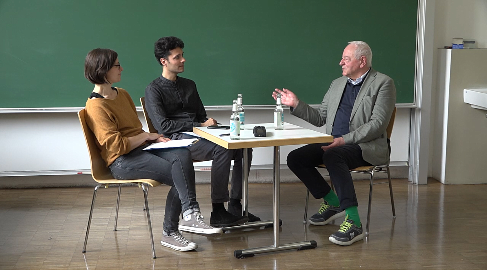 Interview mit Erich Gantzert-Castrillo, 3 Personen sitzen an einem Tisch
